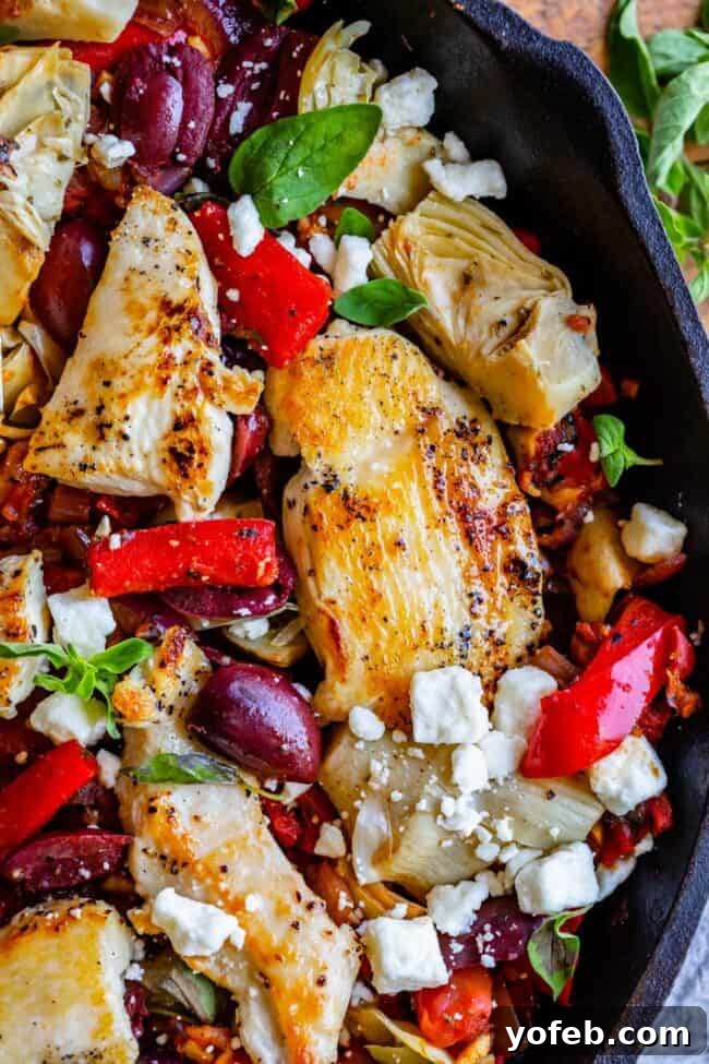 Savory Greek Chicken and Veggie Pasta Close-up of Greek Pasta with Chicken and Zoodles, showcasing tender chicken strips, colorful bell peppers, sun-dried tomatoes, artichoke hearts, and Kalamata olives, a perfect 30-minute healthy dinner.