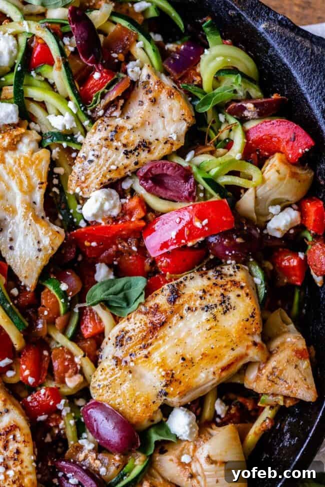 Healthy Chicken Zoodle Greek Dish Chicken and zoodles plated, highlighting the lean protein and spiralized zucchini alongside colorful Mediterranean vegetables, a low-carb alternative for Greek pasta.