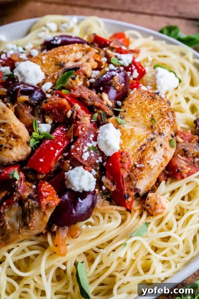 Mediterranean Veggie Pasta with Chicken A vibrant bowl of Greek pasta, featuring an abundance of fresh vegetables like tomatoes and bell peppers, combined with briny olives and crumbled feta cheese, adaptable with zoodles.