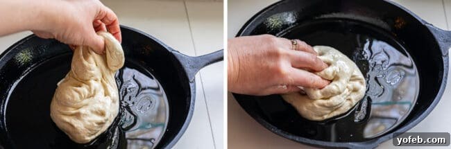 Skillfully shaping pizza dough within a well-oiled cast iron skillet to achieve an even base.