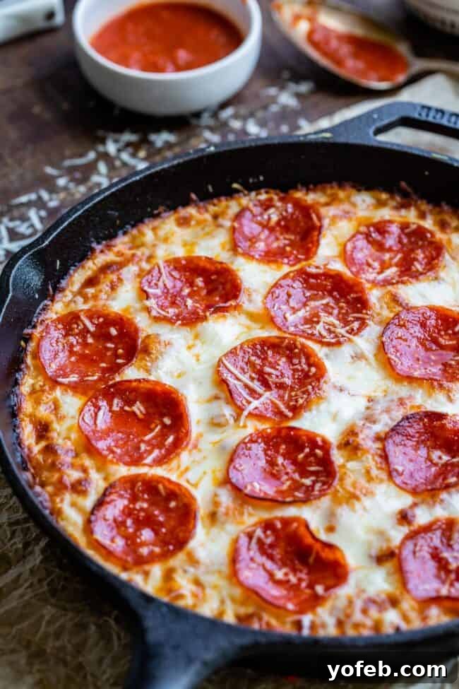 A perfectly baked pan pizza with crispy pepperoni and melted cheese, fresh out of the cast iron skillet.