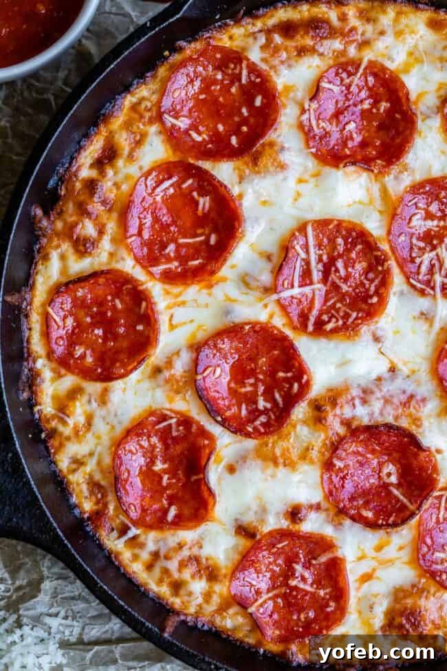 A close-up of a Pepperoni Pizza Hut style pan pizza with luscious melted cheese and perfectly toasted pepperoni slices on wax paper.