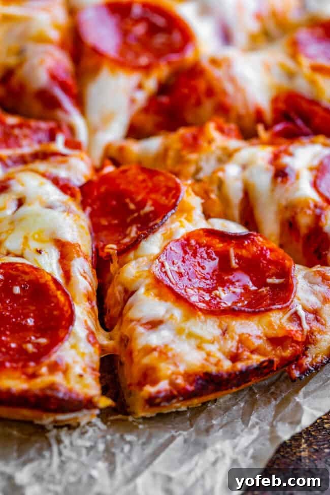 A beautifully baked pan pizza, sliced and ready to serve, showcasing its perfectly melted cheese and golden crust.