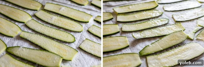 Close-up of salted zucchini noodles laid out on paper towels, with visible water droplets on the surface after the salting process. This image clearly demonstrates the effectiveness of salting in drawing out excess moisture from zucchini, a crucial step for preventing watery lasagna.