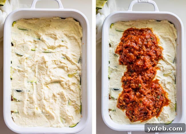 A white casserole dish with a layer of creamy ricotta cheese spread over zucchini, followed by a generous topping of rich marinara sauce. This depicts a crucial layering step for a delicious and well-structured zucchini lasagna, building up the flavorful components.