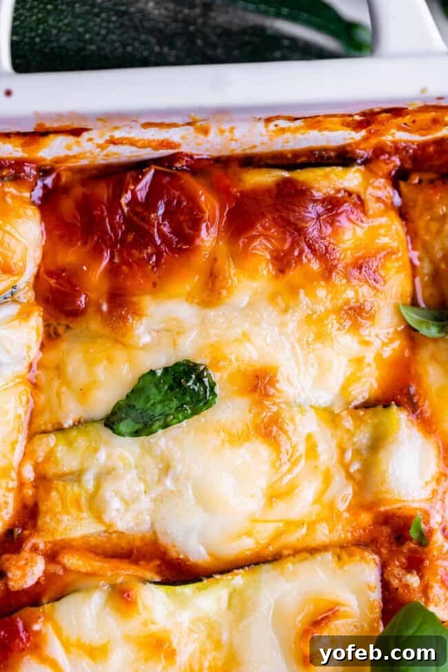 A freshly baked zucchini noodle lasagna in a white pan, artfully garnished with fresh basil leaves. This image highlights the inviting warmth and rich colors of the low-carb, keto-friendly dish, ready to be served as a healthy and delicious meal.