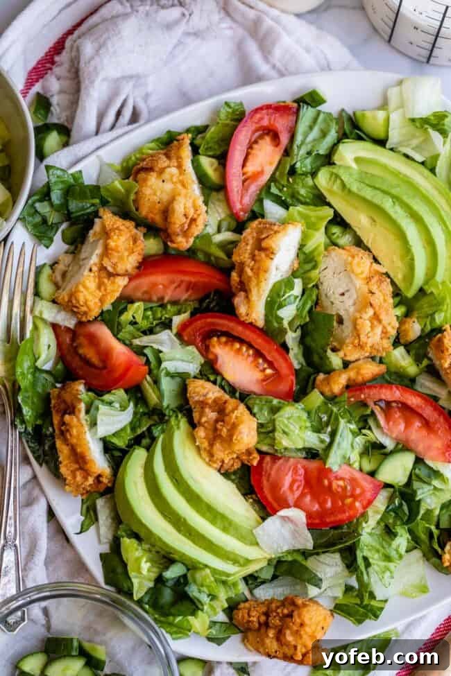 Chicken Salad Ready to Serve Crispy chicken salad on a plate with avocado and tomatoes