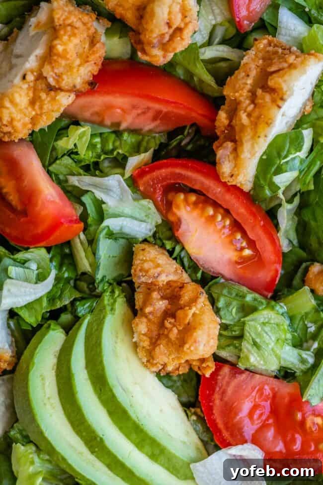 Fried Chicken Salad Fried chicken salad with tomato and avocado close up