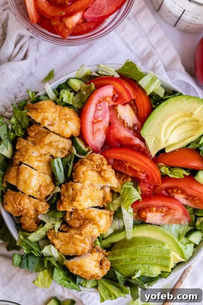 Chicken Salad with Fresh Greens Crispy chicken salad on a plate with avocado and tomatoes