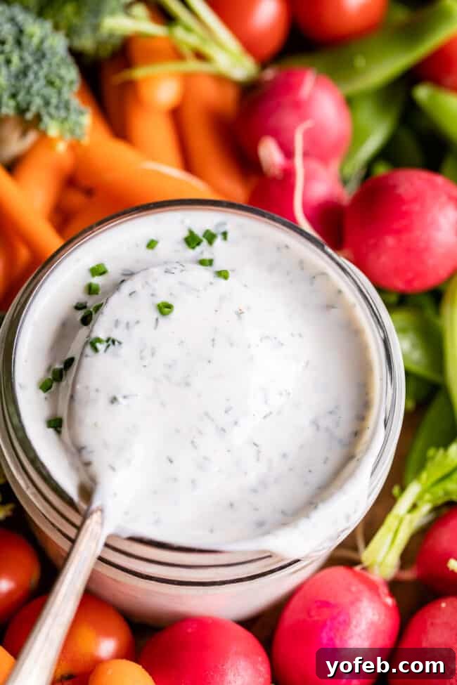 Homemade Buttermilk Ranch Dressing buttermilk ranch dressing in a glass jar surrounded by fresh veggies.