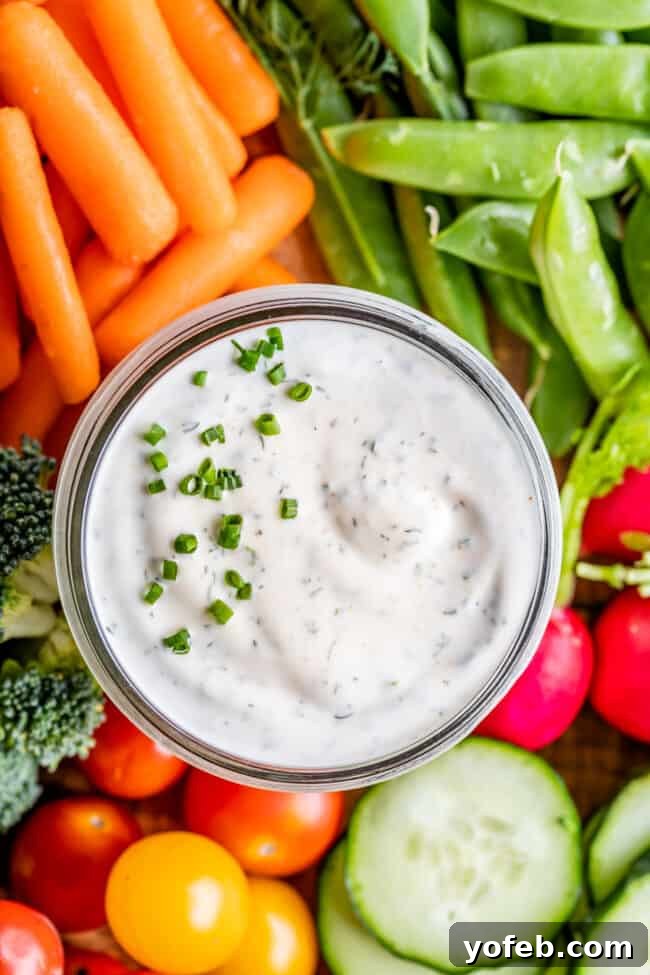 Homemade Buttermilk Ranch Dressing overhead of buttermilk ranch dressing in a glass jar with fresh vegetables surrounding it.