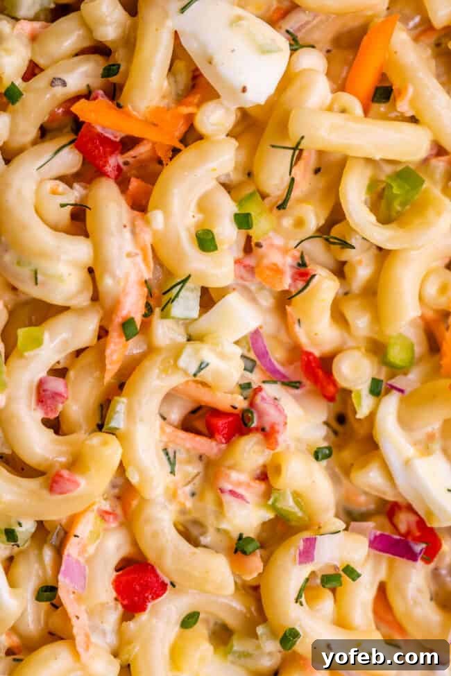 Classic Creamy Macaroni Salad 6 macaroni salad shot from overhead, showcasing its perfectly mixed ingredients and creamy dressing, inviting viewers to dig in.
