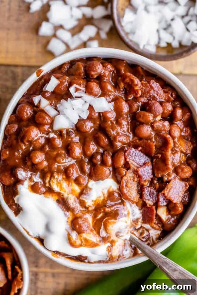pinquito beans in a bowl with sour cream and chopped onions.