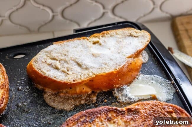 Golden Glazed French Toast 11 Brioche French toast frying on an electric griddle, with granulated sugar sprinkled on top to caramelize.