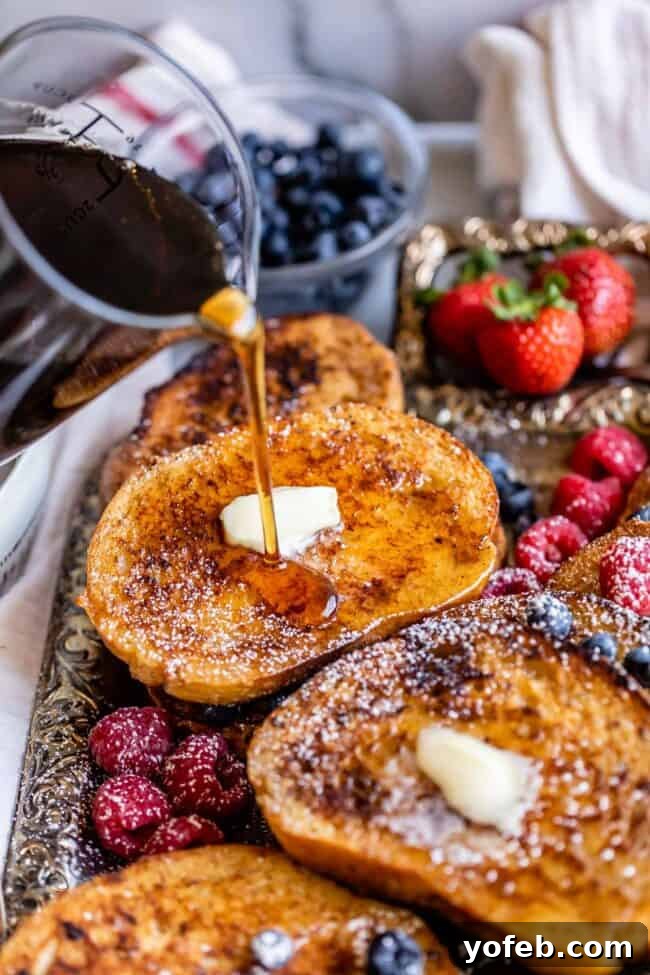 Golden Glazed French Toast 14 Pouring maple syrup over a freshly cooked tray of brioche French toast.