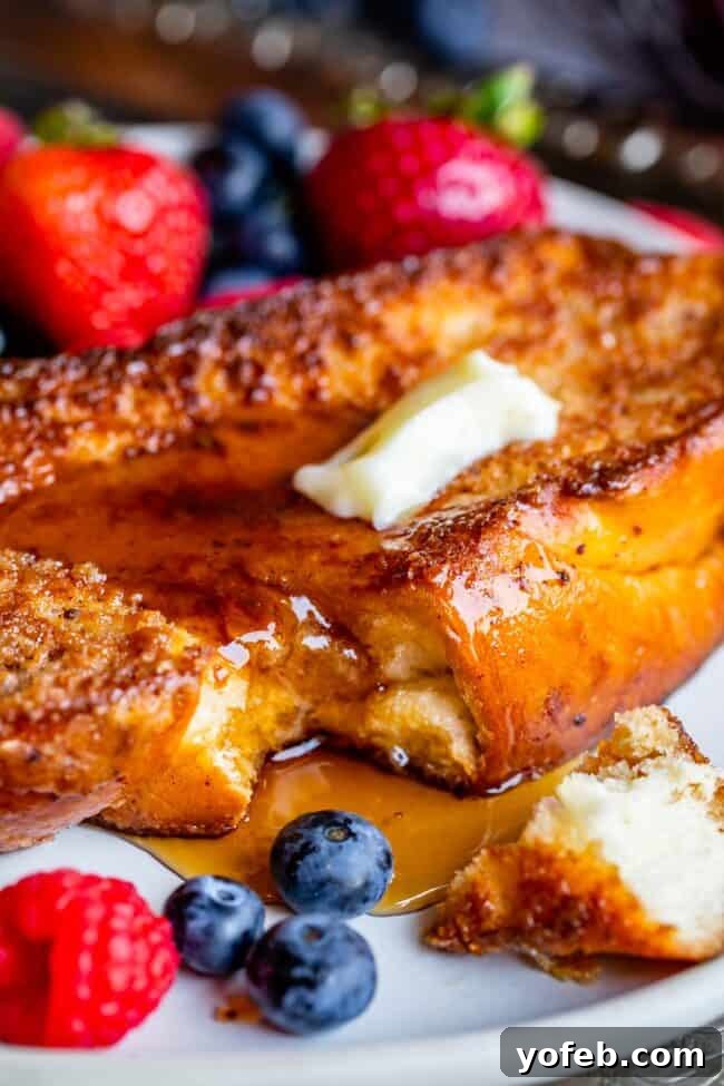 Golden Glazed French Toast 4 The best French toast, on a plate with fresh berries, butter, and maple syrup.