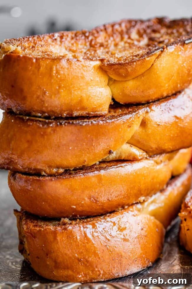 Golden Glazed French Toast 7 A stack of thick-sliced French toast made with challah bread, ready to be served.