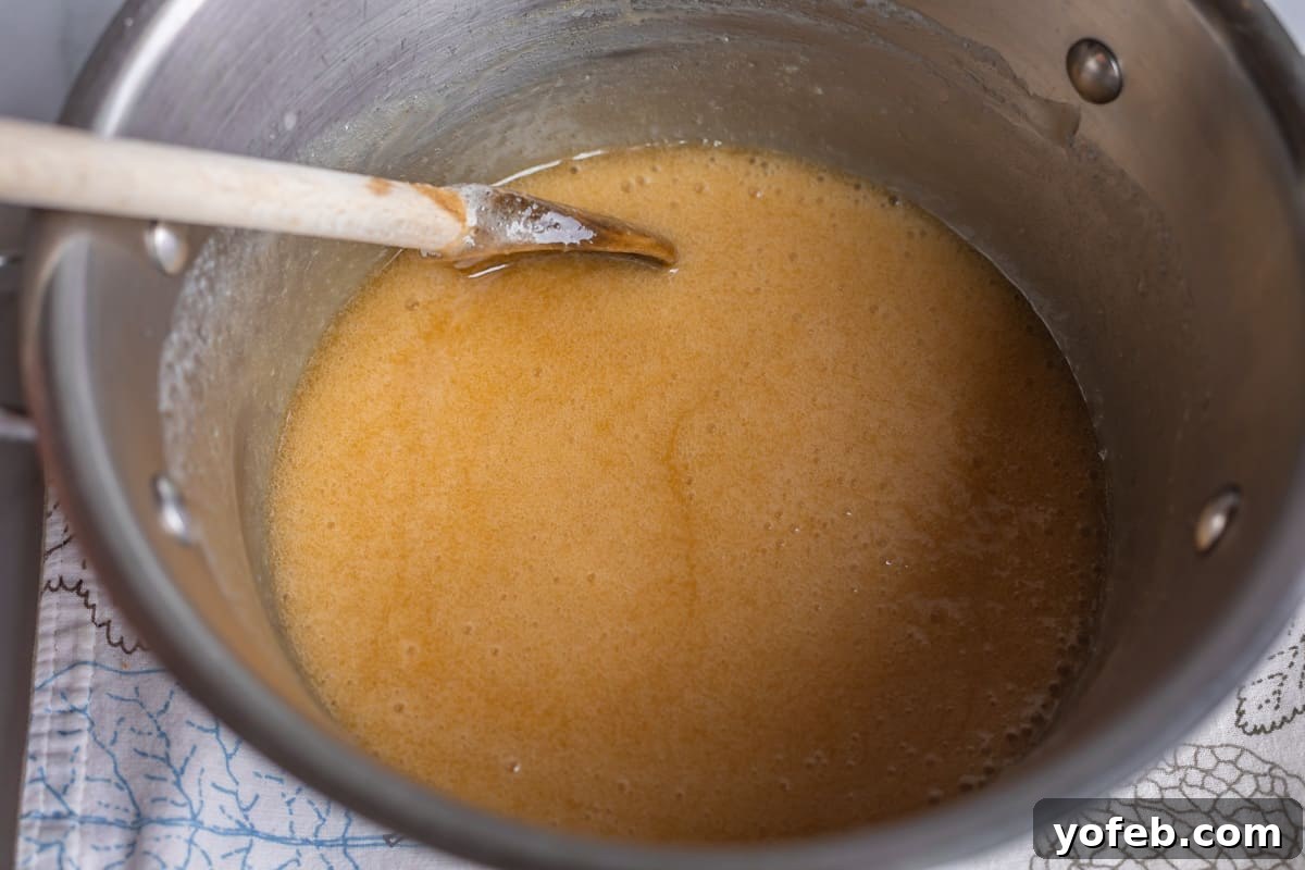 Velvet Smooth Buttermilk Syrup 12 buttermilk syrup in a pot with a wooden spoon.