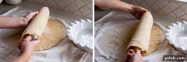 A pie dough being gently rolled onto a marble rolling pin, preparing it for transfer to the pie plate.