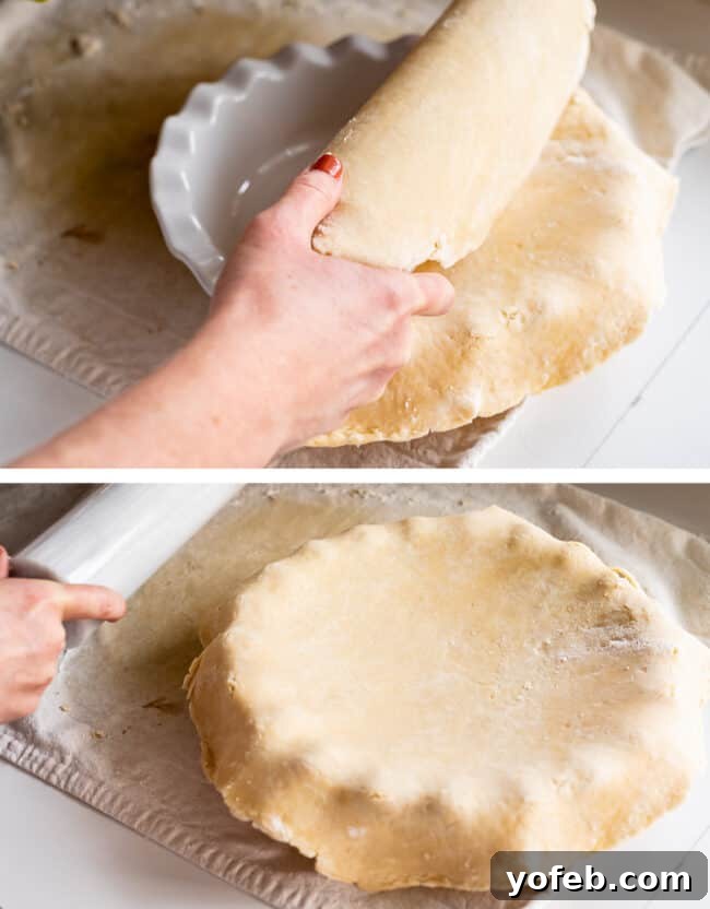 A pie crust dough being carefully placed into a pie plate using a rolling pin, a simple and effective transfer method.