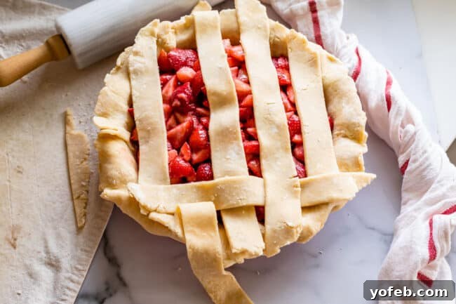 A Visual Guide to Making a Lattice Pie Crust 7 folding back strips of pie dough to make a lattice pie crust on strawberry pie