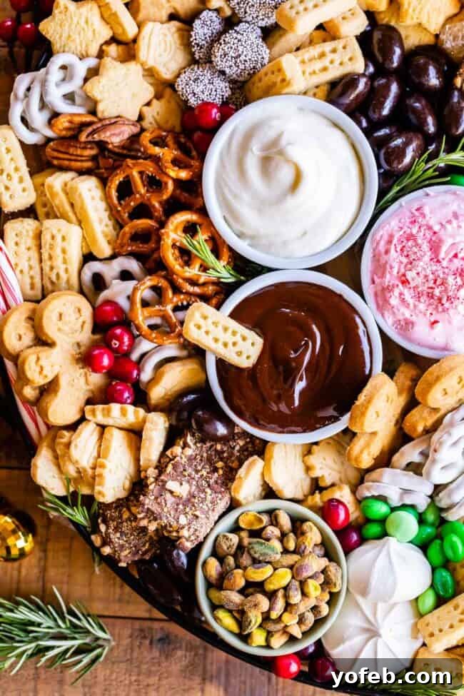 Sweet Grazing Boards 3 A festive holiday dessert platter featuring a variety of dippables like pretzels, meringues, and gingerbread men, alongside three distinct dips.