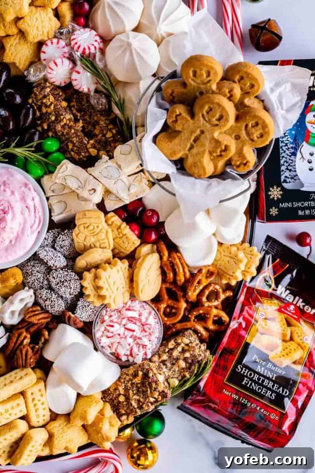 Sweet Grazing Boards 6 A beautifully arranged holiday dessert charcuterie board featuring Walkers Shortbread, festive gingerbread men, fresh cranberries, and crushed candy canes, ready for sharing.