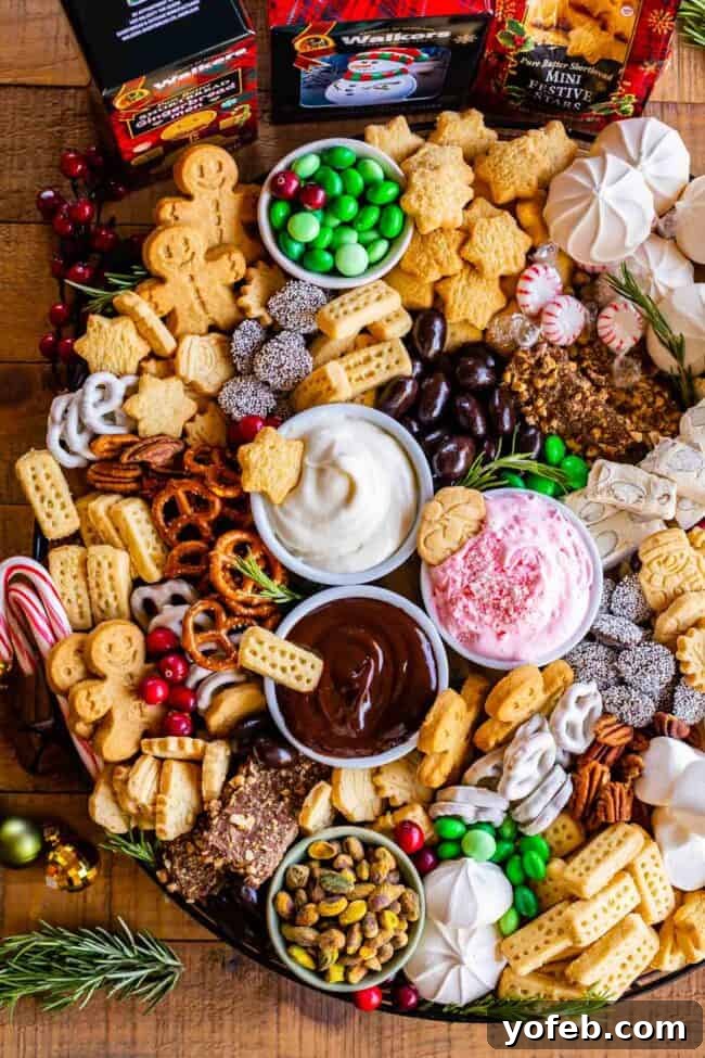 Sweet Grazing Boards 9 A lavish dessert charcuterie board overflowing with various sweets, including pretzels, dips, Walkers Shortbread, chocolate-covered almonds, colorful candies, meringues, and nuts, perfect for a grand holiday spread.