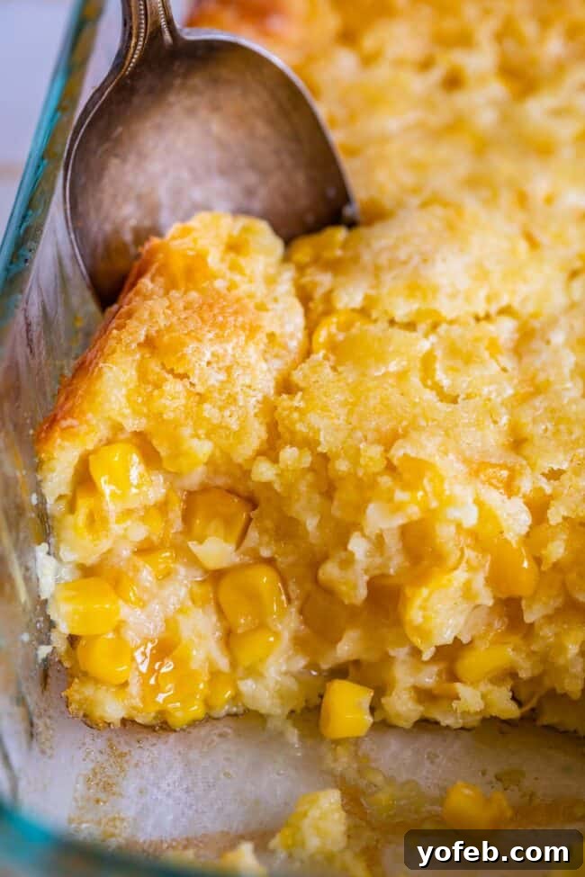Golden Cornbread Delight 6 jiffy cornbread casserole in a pan with a spoon.