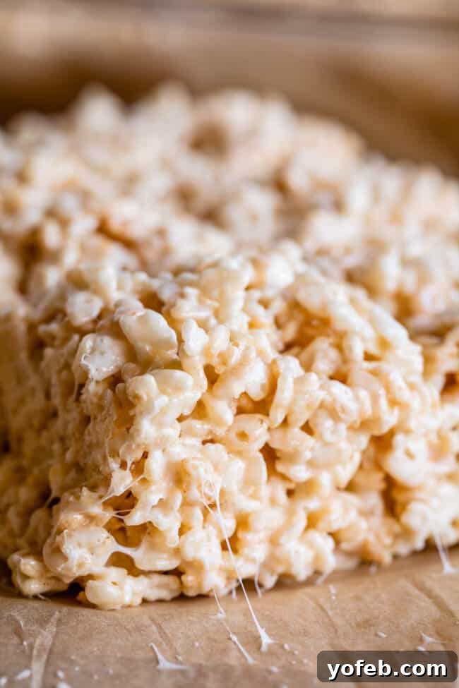 Foolproof Rice Krispies Treats 4 Gooey Rice Krispie Treats on parchment paper, ready to be served.
