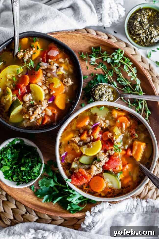Two bowls of hearty Turkey Vegetable Soup on a rustic wooden board, garnished with fresh parsley and thyme for a vibrant presentation.