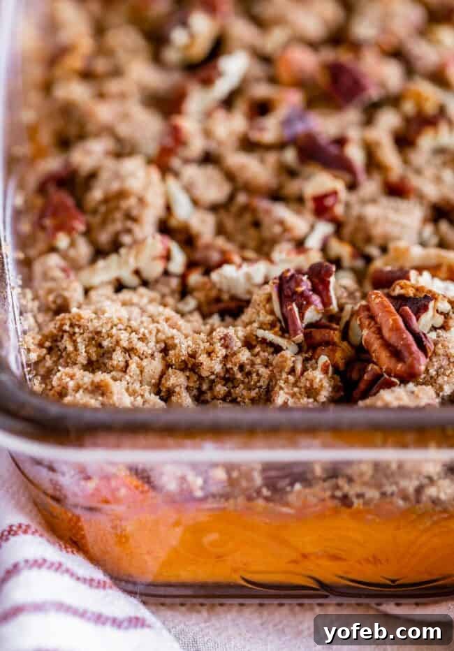 Heavenly Sweet Potato Crumble 3 Sweet potato casserole with a pecan topping in a clear glass baking dish, ready to be served.