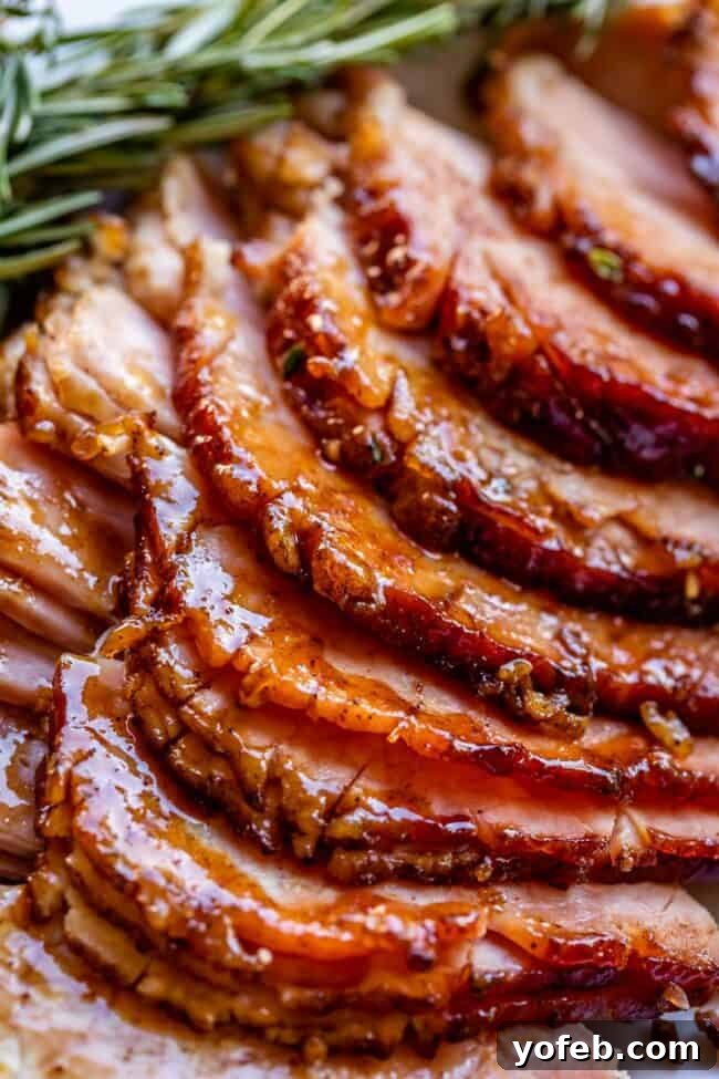 Ultimate Honey Baked Ham 8 Hands massaging honey glaze into a spiral ham, demonstrating the application technique for the copycat recipe.
