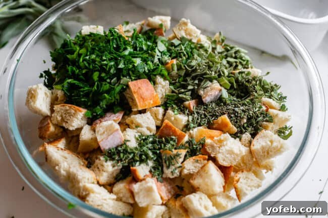 The Ultimate Thanksgiving Stuffing 15 fresh chopped herbs on top of toasted bread cubes in a bowl