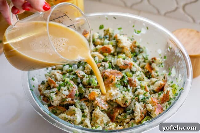 The Ultimate Thanksgiving Stuffing 17 pour broth into a bowl of bread and herbs