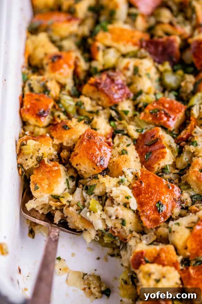 The Ultimate Thanksgiving Stuffing 25 Thanksgiving stuffing in a white dish with spoon