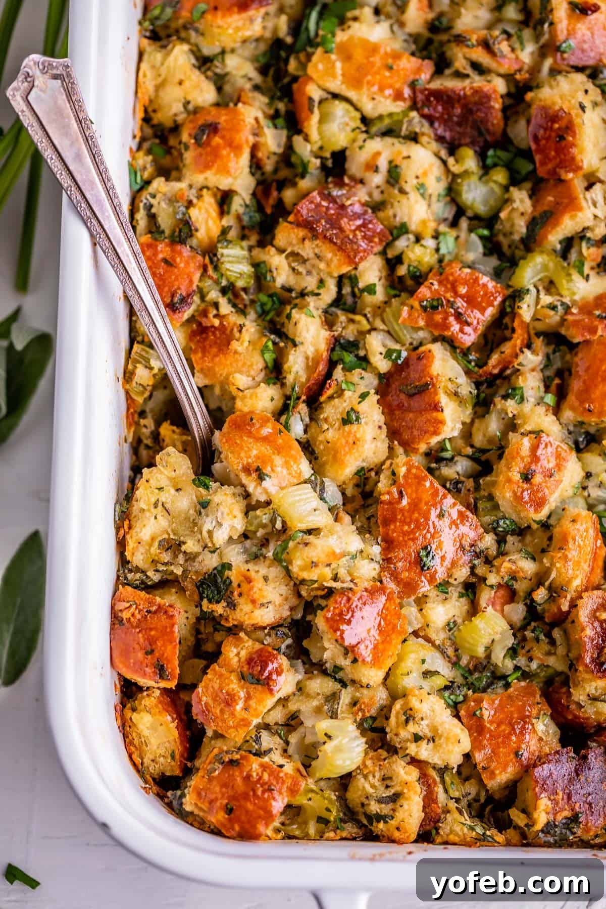The Ultimate Thanksgiving Stuffing 27 thanksgiving stuffing in a white dish with a spoon, over head