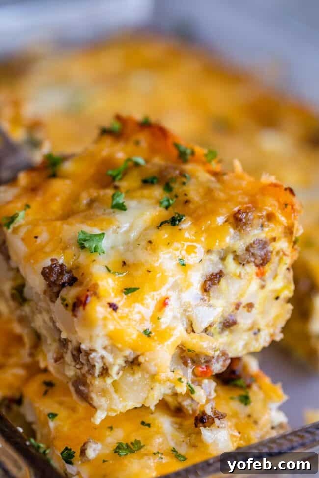 The Ultimate Sausage Breakfast Casserole 11 sausage breakfast casserole lifted on a serving spoon.