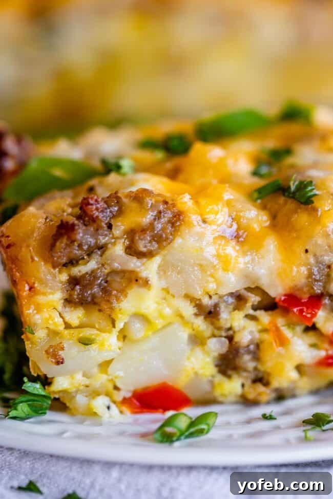 The Ultimate Sausage Breakfast Casserole 4 breakfast casserole with sausage and hashbrowns on a white plate.