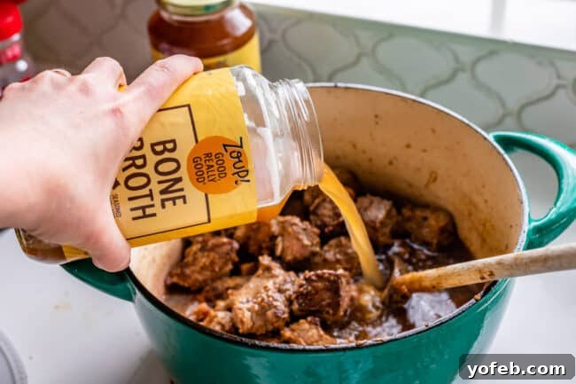 Classic French Beef Bourguignon 10 Rich Zoup! Beef Bone Broth being poured into a simmering stew, adding depth and flavor to the dish.