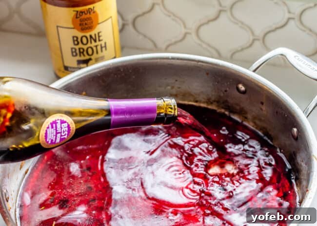 Classic French Beef Bourguignon 12 Red Pinot Noir wine being poured into a hot pan, an essential step for reducing the wine to create a rich base for the stew.