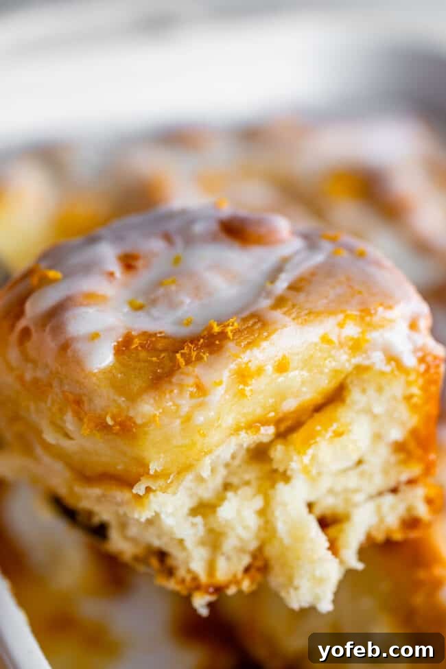 Meyer Lemon Sunshine Rolls 16 meyer lemon sweet roll with glaze being lifted on a spatula