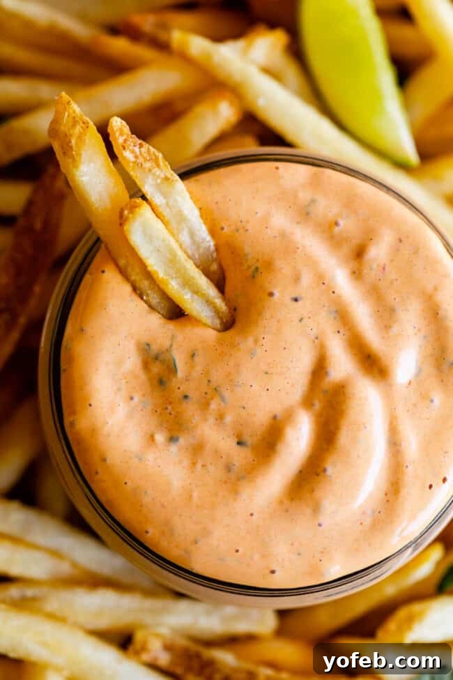Whip Up Your Own Smoky Chipotle Sauce 13 A jar of homemade chipotle mayo sauce with golden, crispy fries dipped into it, ready to eat.
