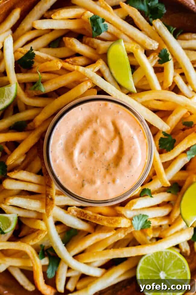 Whip Up Your Own Smoky Chipotle Sauce 5 Chipotle mayo recipe in a jar, generously surrounded by perfectly golden fries and bright lime slices.