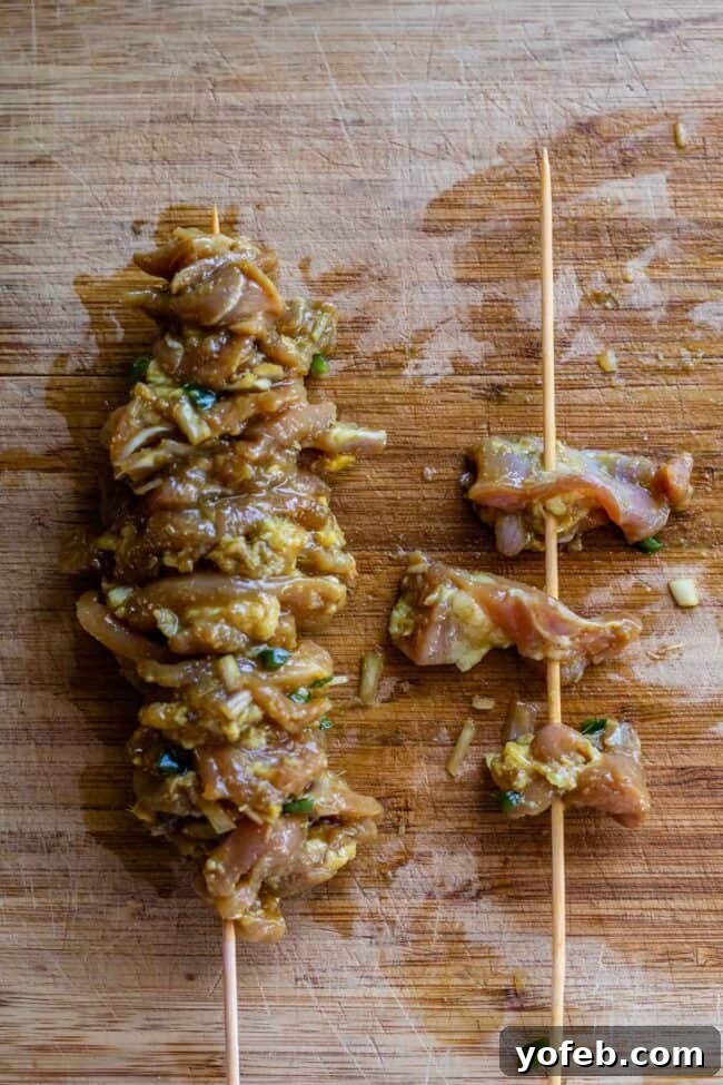Authentic Thai Chicken Satay with Creamy Peanut Sauce 11 A step-by-step image demonstrating how to properly thread chicken pieces onto skewers for traditional Thai Chicken Satay, showing them tightly packed.