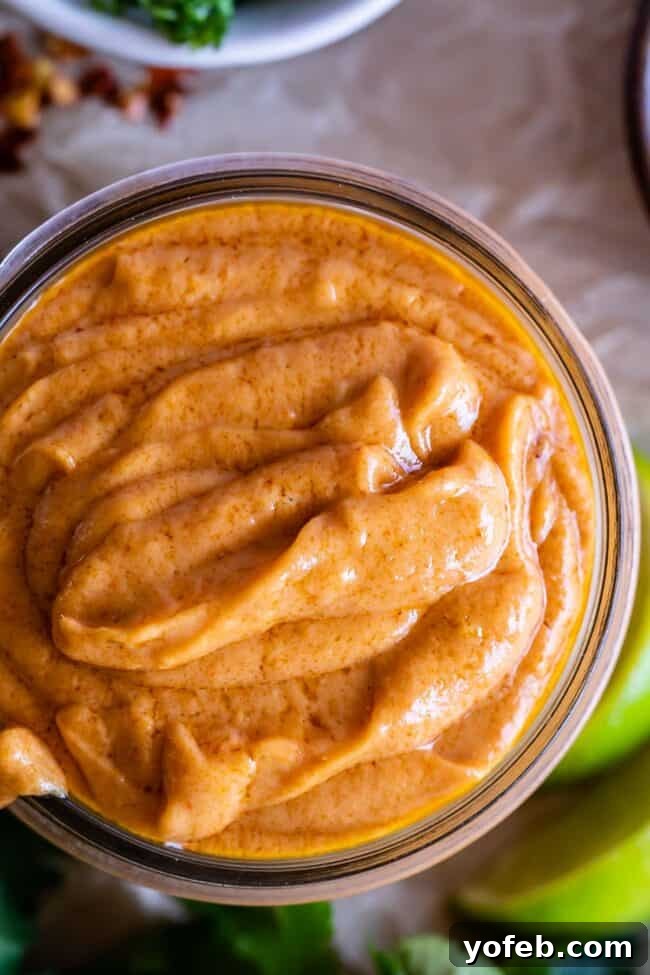 Effortless Homemade Peanut Sauce 8 An inviting overhead shot of easy Thai peanut sauce generously scooped into a glass jar, highlighting its thick and creamy texture, ready to be served.