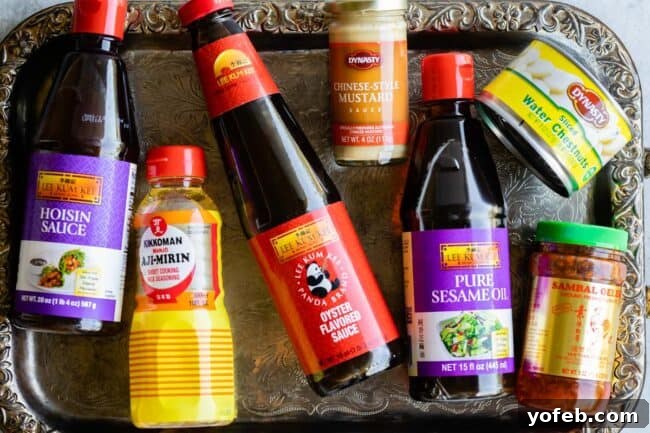 P.F. Chang's Style Lettuce Wraps at Home 6 Bottles of essential Asian sauces and ingredients on a tray: hoisin, aji mirin, oyster sauce, hot mustard, sesame oil, water chestnuts, chili garlic sauce.