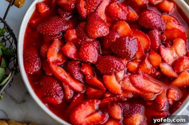 A bowl of rich, sliced strawberry topping, showcasing its juicy consistency.