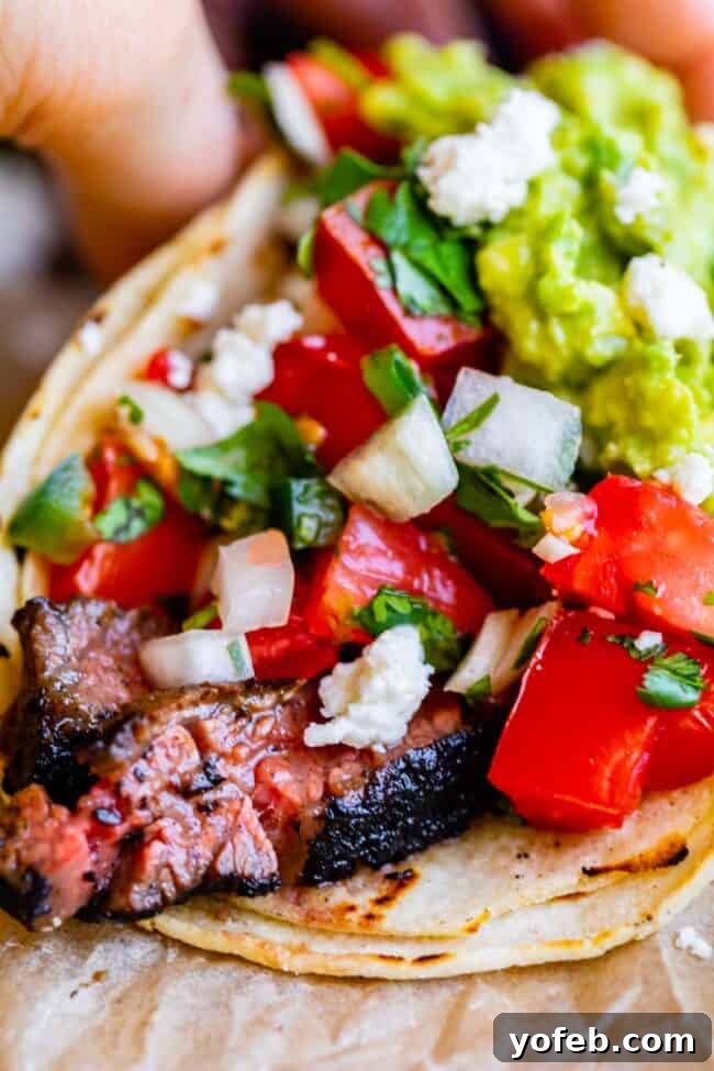 Mastering Carne Asada 2 a carne asada taco with guacamole and pico de gallo.