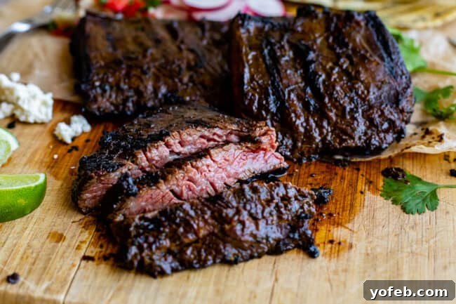 Mastering Carne Asada 19 grilled skirt steak on a cutting board cut against the grain.